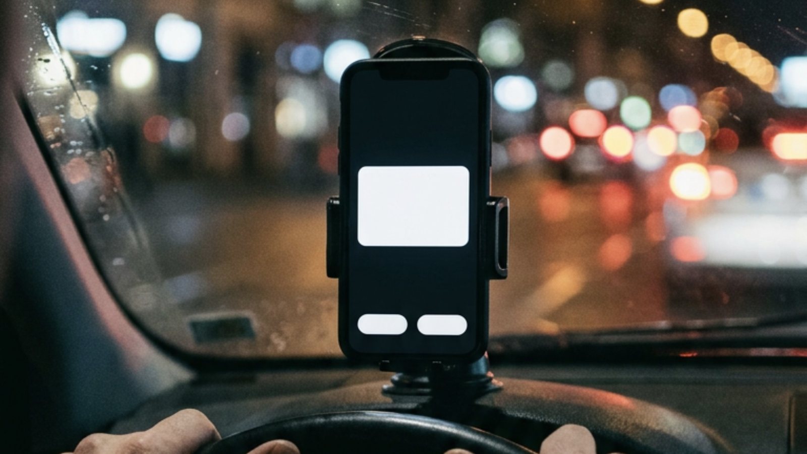 Celular preso no painel de um carro à noite, com a tela preta e um aviso branco sem texto no meio, as mãos do motorista no volante e as luzes da cidade desfocadas atrás do para-brisa